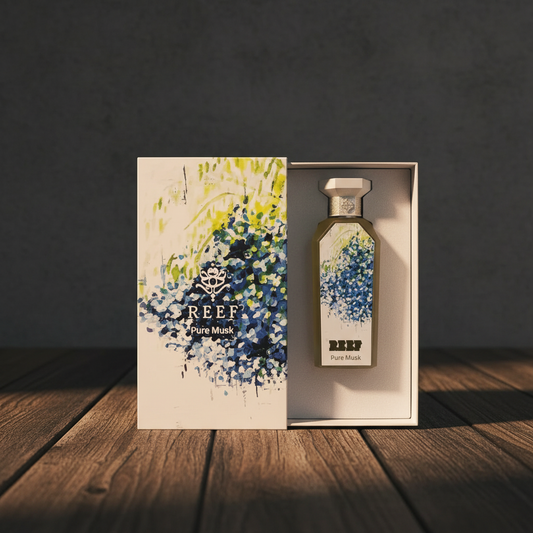 Reef Pure Musk perfume bottle and gift box on dark wood surface, charcoal background